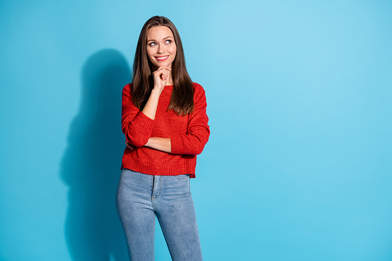 Woman posing with a bright blue background.